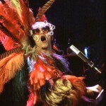 Elton John in concert as a bird... rooster... something