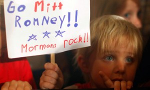 Kid holding sign: go mitt romney. mormons rock!