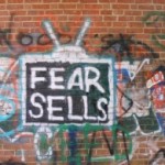 Fear sells. Brick wall graffiti.