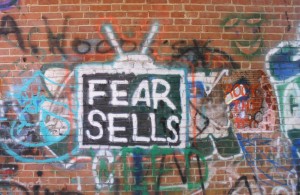Fear sells. Brick wall graffiti.