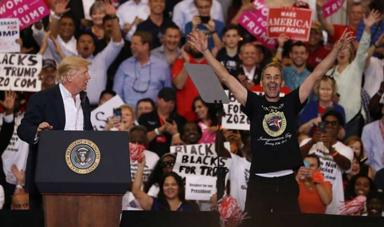 Trump rally, FL, supporter on stage, crowd in background